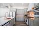 This kitchen showcases an island with a copper sink and stainless steel appliances, alongside modern gray cabinetry at 737 E Boston St, Gilbert, AZ 85295