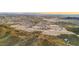 Expansive aerial view of the new construction neighborhood with mountain views and desert landscape at sunset at 7400 W Quail Track Dr, Peoria, AZ 85383