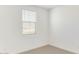 Bright bedroom featuring neutral carpet, a window with blinds, and fresh white paint at 7400 W Quail Track Dr, Peoria, AZ 85383