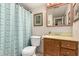 Small bathroom with a blue patterned shower curtain, a toilet, and wood cabinet with a yellow countertop at 76 N 133Rd St, Chandler, AZ 85225