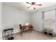 Bedroom featuring a ceiling fan, a desk, a laptop, a chair, and a weight-lifting machine at 76 N 133Rd St, Chandler, AZ 85225