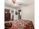 Bedroom featuring patterned bedding, ceiling fan, tiled floor, and wooden dresser at 76 N 133Rd St, Chandler, AZ 85225