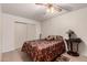 Bedroom with patterned bedding, ceiling fan, tiled floor, and closet at 76 N 133Rd St, Chandler, AZ 85225