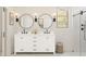 Modern bathroom with a double sink vanity, round mirrors, and a glass-enclosed shower at 7981 W Griswold Rd, Peoria, AZ 85345