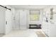 Bright bathroom featuring a glass shower, white cabinets, a bench, and a window at 7987 W Griswold Rd, Peoria, AZ 85345