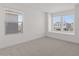 This bright bedroom offers great natural light from the large windows and features neutral carpet and fresh, white walls at 7987 W Griswold Rd, Peoria, AZ 85345