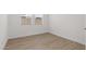 Empty bedroom featuring light wood floors, white walls, a window and a door at 7987 W Griswold Rd, Peoria, AZ 85345
