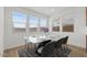 Contemporary dining area with a sleek white marble table, modern chairs, and plenty of natural light at 7987 W Griswold Rd, Peoria, AZ 85345