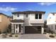 Charming two-story home with stone accents, a dark gray roof, and an attached two-car garage at 7987 W Griswold Rd, Peoria, AZ 85345