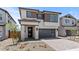 Beautiful two-story home with a modern design, dark gray garage door, and inviting stone-accented entrance at 7987 W Griswold Rd, Peoria, AZ 85345