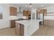 Stylish kitchen with a large quartz island, stainless steel appliances, wood cabinetry, and pendant lighting at 7987 W Griswold Rd, Peoria, AZ 85345