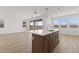 Open kitchen features a large island with seating, sink, and stainless steel appliances and wood floors at 7987 W Griswold Rd, Peoria, AZ 85345