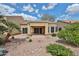 An inviting outdoor patio features stone flooring and meticulously designed desert landscaping, perfect for relaxation at 8347 W Taro Ln, Peoria, AZ 85382