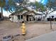 Quaint home featuring a covered porch and basic landscaping awaiting restoration to its original charm at 8350 W Monroe St, Peoria, AZ 85345