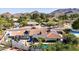 Aerial view showcasing the backyard pool, patio, terracotta tile roof, and lush landscaping against a mountain backdrop at 9234 N 33Rd Way, Phoenix, AZ 85028