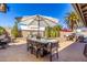 Entertaining backyard with a long dining table, patio umbrella, palm tree, and desert landscaping at 9234 N 33Rd Way, Phoenix, AZ 85028