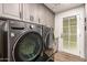 Laundry room featuring modern appliances, gray cabinets, and access to the outside at 9234 N 33Rd Way, Phoenix, AZ 85028