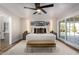 This main bedroom features modern decor, a ceiling fan, and doors that lead to the backyard at 9234 N 33Rd Way, Phoenix, AZ 85028