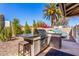 Built-in outdoor kitchen featuring a grill, counterspace, bar seating, and desert landscaping at 9234 N 33Rd Way, Phoenix, AZ 85028