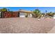 Side view of the house featuring a barrel tile roof, desert landscape, and a fenced-in yard at 9234 N 33Rd Way, Phoenix, AZ 85028