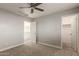 Cozy bedroom with neutral carpet, ceiling fan, and open door to the en-suite bathroom at 9413 W Pioneer St, Tolleson, AZ 85353