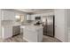 Bright kitchen featuring white cabinets, stainless steel appliances, and center island with quartz countertop at 9413 W Pioneer St, Tolleson, AZ 85353