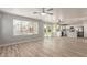 Bright living room featuring new laminate floors, high ceilings, and a kitchen area in the background at 9413 W Pioneer St, Tolleson, AZ 85353