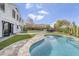 Scenic backyard featuring a large pool, outdoor kitchen, artificial grass and a two-story home at 1001 N 165Th Ave, Goodyear, AZ 85338