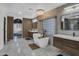 Modern bathroom featuring a soaking tub, dual vanities, unique lighting, and stylish design at 1001 N 165Th Ave, Goodyear, AZ 85338