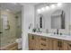 Bathroom with double vanity sinks, marble countertops and a glass-enclosed shower at 1001 N 165Th Ave, Goodyear, AZ 85338