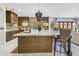 A modern kitchen island featuring a marble countertop, seating, and sleek wood cabinetry at 1001 N 165Th Ave, Goodyear, AZ 85338