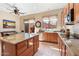 Well-lit kitchen with wood cabinets, granite countertops, stainless appliances, and backyard access at 11489 N 141St St, Scottsdale, AZ 85259