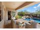 Inviting covered patio with cozy seating and a view of the pool and desert landscaping at 11489 N 141St St, Scottsdale, AZ 85259