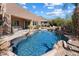 Stunning backyard featuring a freeform pool, rock accents, and desert landscaping at 11489 N 141St St, Scottsdale, AZ 85259