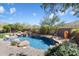 Backyard pool with rock waterfall feature and lush desert landscaping, offering a serene retreat at 11489 N 141St St, Scottsdale, AZ 85259