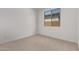 Bright bedroom featuring neutral carpet and a window with neighborhood views at 12374 W Marguerite Ave, Avondale, AZ 85323
