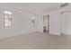 Spacious bedroom featuring neutral carpet, with two windows, adjacent to an ensuite bathroom at 12374 W Marguerite Ave, Avondale, AZ 85323