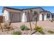 Inviting home with a well-kept landscape, featuring gravel beds, flowering plants, and a spacious driveway leading to a garage at 12374 W Marguerite Ave, Avondale, AZ 85323