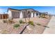 Lovely home with manicured desert landscape, decorative rocks, flowering plants, and a charming paver driveway at 12374 W Marguerite Ave, Avondale, AZ 85323