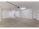 Spacious three-car garage with high ceilings, overhead lighting, and clean concrete flooring, ready for customization at 12374 W Marguerite Ave, Avondale, AZ 85323