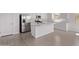 Bright kitchen with white cabinets, stainless steel appliances, a large island, and wood-look tile flooring at 12374 W Marguerite Ave, Avondale, AZ 85323