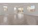 Large living room with tiled flooring, multiple windows, and sliding glass door access to the backyard at 12374 W Marguerite Ave, Avondale, AZ 85323