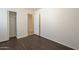 Neutral bedroom with wood-look floors and open closet space at 13011 W Mandalay Ln, El Mirage, AZ 85335