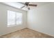 An empty bedroom with a window, a ceiling fan and tile flooring at 13011 W Mandalay Ln, El Mirage, AZ 85335