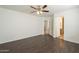 An empty bedroom featuring wood laminate flooring, ceiling fan and access to a bathroom at 13011 W Mandalay Ln, El Mirage, AZ 85335