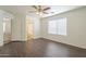 Spacious bedroom with wood-look laminate flooring, ceiling fan, and bathroom access at 13011 W Mandalay Ln, El Mirage, AZ 85335