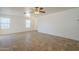 Bright living room featuring tile flooring, a ceiling fan, and multiple windows for natural light at 13011 W Mandalay Ln, El Mirage, AZ 85335