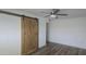 Bright bedroom featuring a modern ceiling fan and stylish wood-look flooring with a barn door closet at 13816 N 103Rd Ave, Sun City, AZ 85351