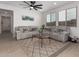 Well-lit living room with tile floors, a ceiling fan, a gray sofa, and a decorative rug at 14377 W Alameda Rd, Surprise, AZ 85387