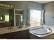 Bright bathroom featuring a large soaking tub, separate shower, and a large vanity mirror at 14435 W Verde Ln, Goodyear, AZ 85395